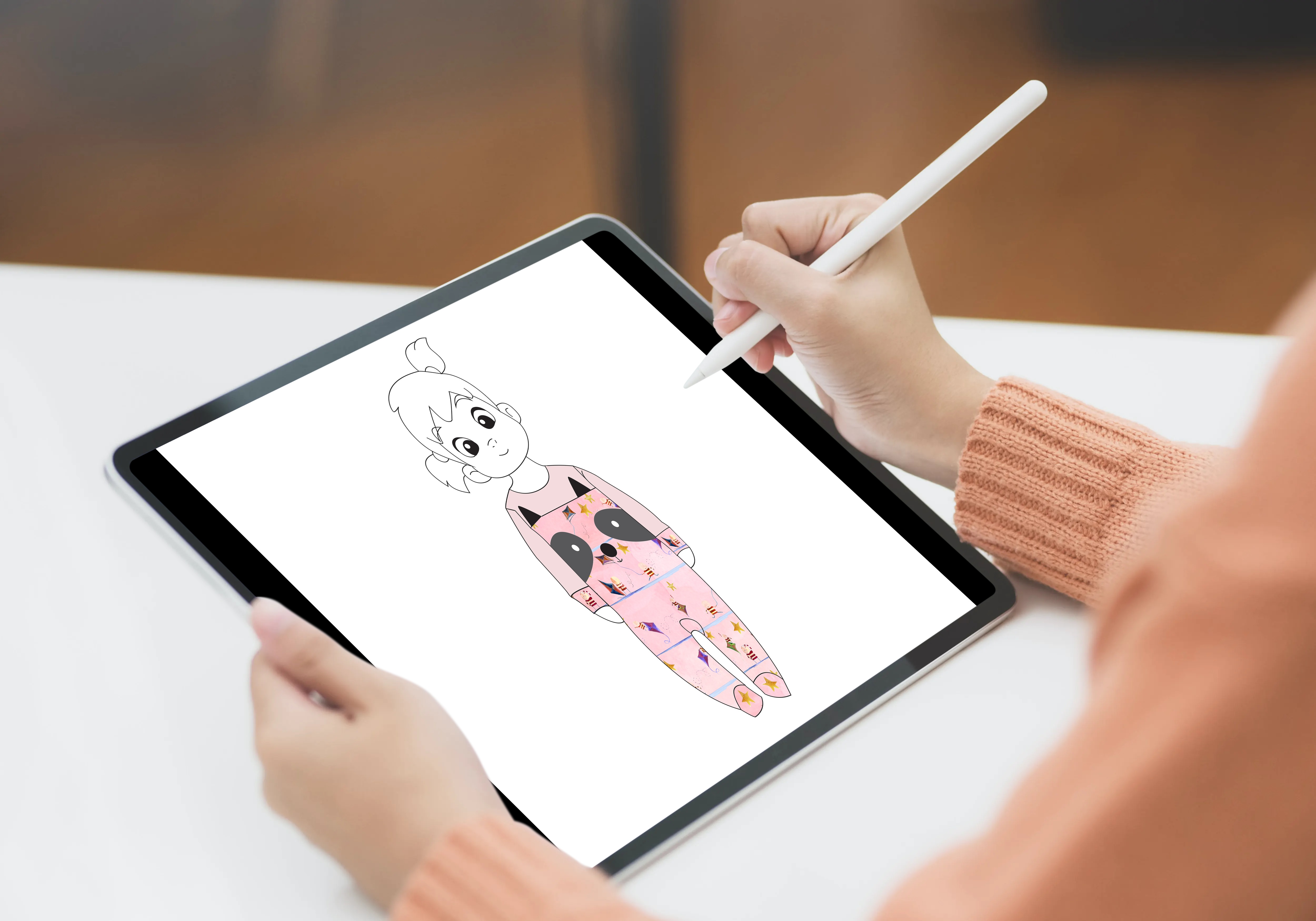 Designing a Bellita character on an iPad with Apple Pencil, the figure dressed in the brand's textile patterns